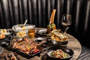 a table with plates of food and a glass of wine at Revier Boutique Hotel Kaprun in Kaprun