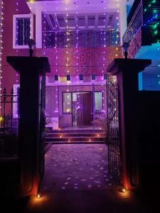 a gate to a house with purple lights on it at Swapno Chhobi in Shānti Niketan
