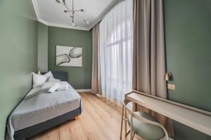 ein Schlafzimmer mit grünen Wänden, einem Bett und einem Stuhl in der Unterkunft HOME1 - District 5 Boutique Hostel in Wien