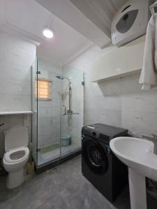Un baño con ducha, inodoro y lavabo. en Mira Haven Apartments, en Abuja