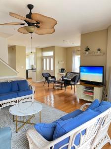 Il comprend un salon doté de canapés bleus et d'une télévision à écran plat. dans l'établissement OceanPinesFamilyBeachRetreat JettdTub KingBed, à Ocean Pines
