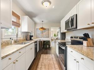 a kitchen with white cabinets and granite counter tops at GVL Retreat with a Hot Tub, Sauna, Firepit and a Gameroom in Taylors