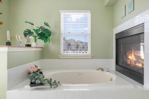 une baignoire blanche dans une pièce avec une cheminée dans l'établissement OceanPinesFamilyBeachRetreat JettdTub KingBed, à Ocean Pines 38 autres photos