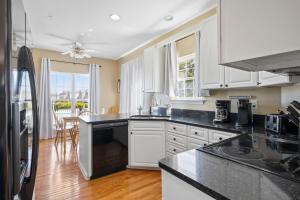 une cuisine avec des armoires blanches et un comptoir noir dans l'établissement OceanPinesFamilyBeachRetreat JettdTub KingBed, à Ocean Pines