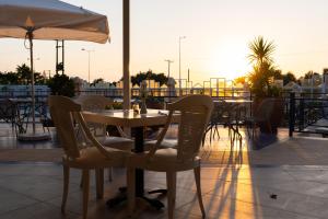 スカレタにあるRethymno Mare Royal & Water Parkのパティオ(テーブル、椅子、パラソル付)