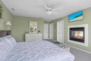 une chambre avec un grand lit blanc et une cheminée dans l'établissement OceanPinesFamilyBeachRetreat JettdTub KingBed, à Ocean Pines