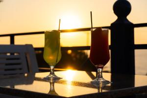 スカレタにあるRethymno Mare Royal & Water Parkの夕日を背景にテーブルに掛けられたグラス2杯