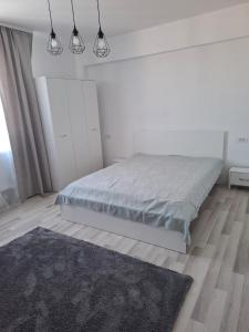Habitación blanca con cama y alfombra en evi home, en Văleni