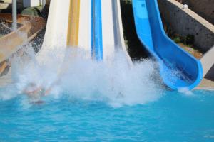 a person sliding down a water slide in a pool at Rethymno Mare Royal & Water Park in Skaleta