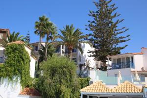 a group of palm trees in front of buildings at Rethymno Mare Royal & Water Park in Skaleta +88 photos