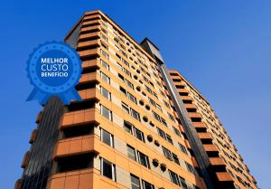 a tall building with a blue sign on it at Max Savassi Apart Service in Belo Horizonte