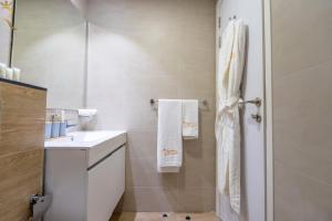 a white bathroom with a sink and a shower at Bright Studio with Balcony the Gate, Masdar City in Abu Dhabi +31 photos
