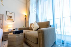 a living room with a couch and a large window at Bright Studio with Balcony the Gate, Masdar City in Abu Dhabi