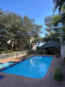 a swimming pool in front of a building at Umdloti Beach Unit in Umdloti