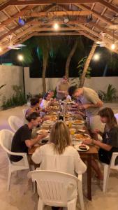 a group of people sitting at a long table eating food at The Palm Ray Rasdhoo in Rasdu +43 photos