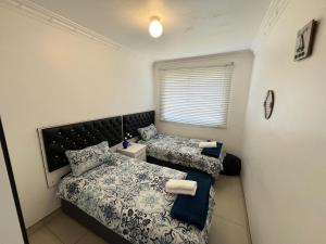 a bedroom with two beds and a window at Umdloti Beach Unit in Umdloti +19 photos