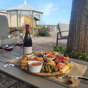 a plate of food with a bottle of wine and wine glasses at L'écrin fleuri in Allerey +41 photos