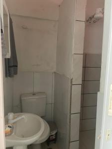 a small bathroom with a toilet and a sink at JK térreo Zona Norte in Porto Alegre