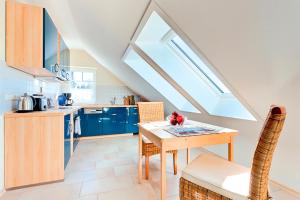 a kitchen with a dining table and a skylight at Ferienhaus LampRieger Fewo 1 OG in Wieck