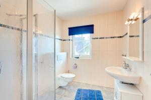 a bathroom with a shower and a toilet and a sink at Ferienhaus LampRieger Fewo 1 OG in Wieck +6 photos