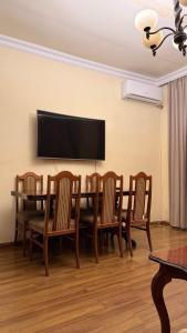 een eetkamer met een tafel en stoelen en een flatscreen-tv bij Guest House - Manandyan 20 in Jerevan +10 foto's