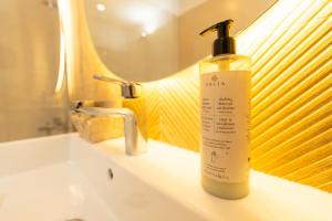 a bottle of soap sitting on a bathroom sink at CH Apartments Urban Plaza in Braşov +137 photos