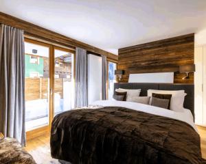 a bedroom with a large bed and a large window at Snow Latern Apartment st Anton in Sankt Anton am Arlberg