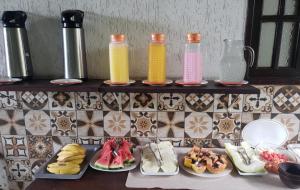 a counter with plates of food and bottles of juice at Pousada Porto Búzios in Búzios +70 photos