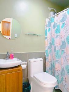 a bathroom with a toilet and a shower curtain at Angsana Breeze-Alpine Crosswinds Tagaytay in Ulot