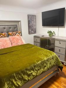 Schlafzimmer mit einem großen grünen Bett und einem Flachbild-TV in der Unterkunft Stunting Sunburst Peaceful Palace in Center Line + 27 Fotos