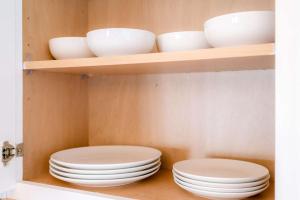 a shelf with white bowls and plates on it at Lozano Lake House in Buncome