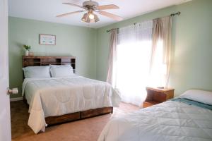 a bedroom with two beds and a ceiling fan at Lozano Lake House in Buncome