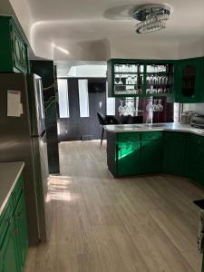 eine grüne Küche mit grünen Schränken und einem Kühlschrank in der Unterkunft Stunting Sunburst Peaceful Palace in Center Line