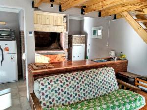 a kitchen with a couch and a counter with a refrigerator at Ñandú Quincho in Santa Rosa