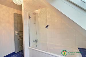 a shower with a glass door in a bathroom at Du golfe in Crach