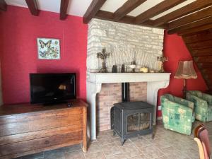 a living room with a fireplace and a television at Chez Pauline in Grimault