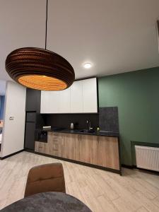 eine Küche mit einem Tisch und einer großen Leuchte in der Unterkunft Apartments on Sennaya Street in Mykolajiw