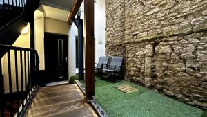 una pared de piedra con un banco junto a un edificio en Le petit Cocon, en Nevers