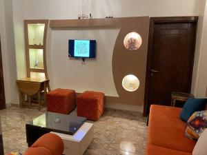 a living room with a couch and a flat screen tv at Luxe Nest Luxor Serviced Apartments 101 in Luxor