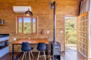 une cuisine avec un poêle à bois dans une cabane dans l'établissement Cabana de luxo na Serra Catarinense VST018, à São Paulo dos Pinhais