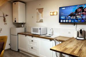 Una cocina con una mesa y un televisor en la pared. en Le petit Cocon, en Nevers