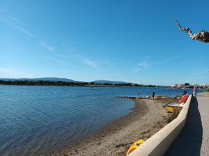 a beach next to the water with a boat on it at Villa Pinede du Golf PORT LEUCATE in Port Leucate +4 photos