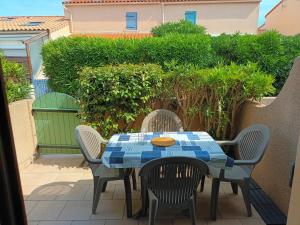 a table and chairs on a patio at Villa Pinede du Golf PORT LEUCATE in Port Leucate