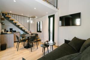 een woonkamer met een bank en een tafel met stoelen bij RoDous Luxury Apartments Preveza in Preveza