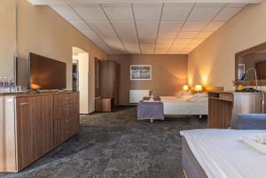 una camera d'albergo con un letto e una televisione di Hotel Olimpijski a Oświęcim