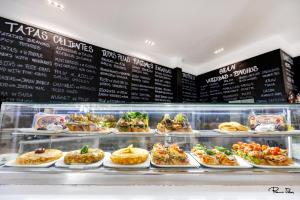 a display case filled with lots of different types of food at Hotel Marítimo Urban in Alicante