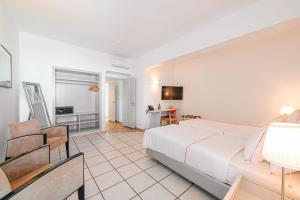 a bedroom with a large white bed and a desk at Hotel Carvoeiro Plaza in Carvoeiro