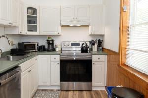 eine Küche mit weißen Schränken und einem Herd mit Backofen in der Unterkunft Entire 1 Bdrm house 5 mins from NWMC and DwnTwn in Saint Albans + 18 Fotos