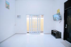 a white room with a door and a television at SeGuestHouse in Banda Aceh