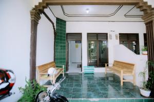 a house with two benches and a scooter parked in front at SeGuestHouse in Banda Aceh